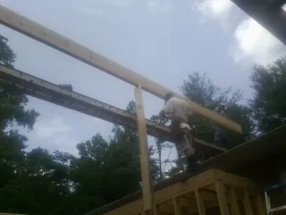 Carpenter setting a ridge beam over a new addition frame — Ice Dam Removal by Roofing Brothers in Bingham Canyon