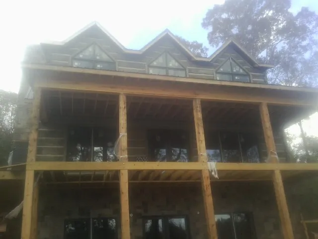Dormers and porch framing on a large log home under construction — Roof Coating work by our crew in Bingham Canyon