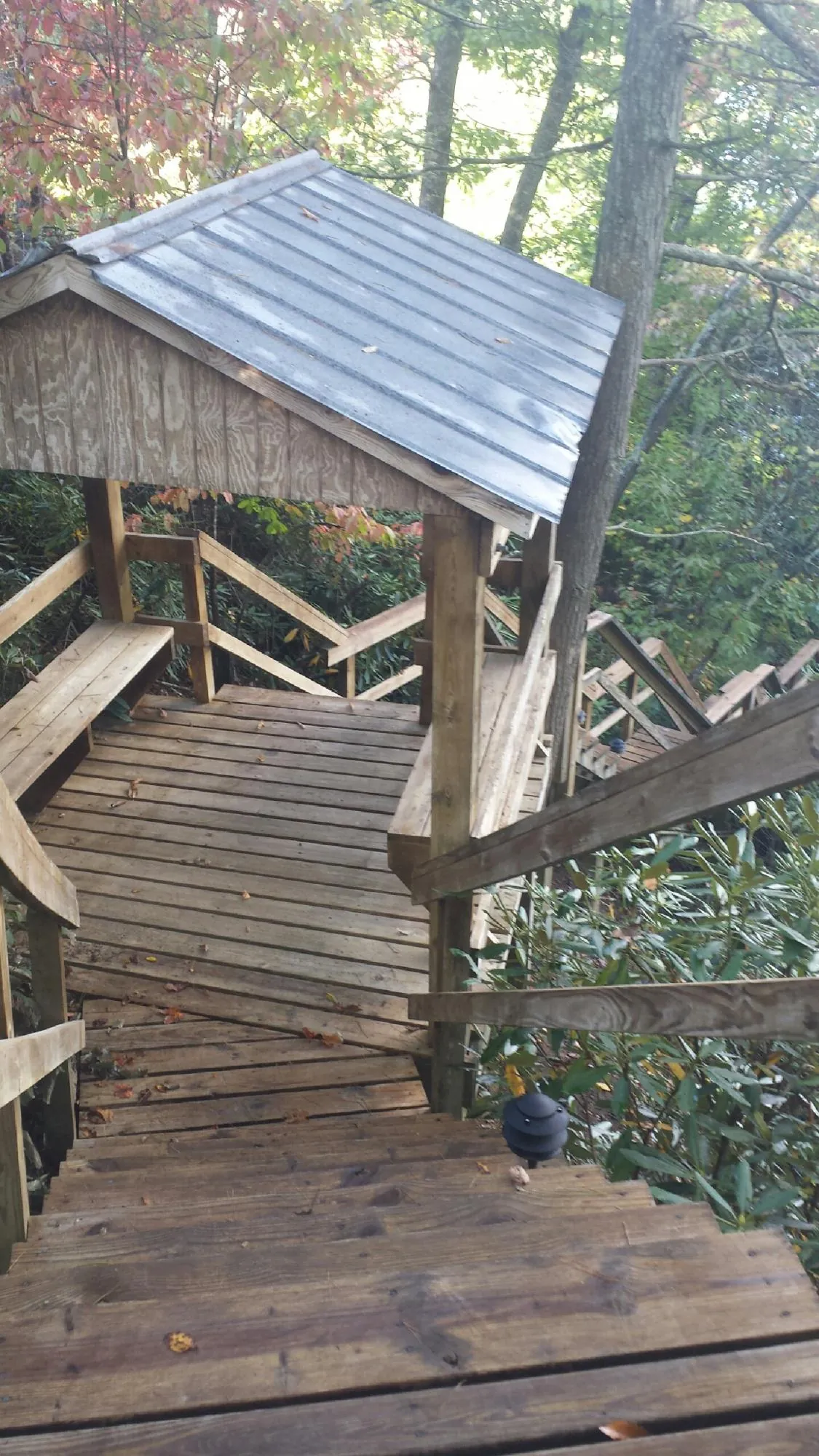 Metal roofed shelter over wooden steps on a wooded walkway — Skylight Repair & Installation work by our crew in Bingham Canyon