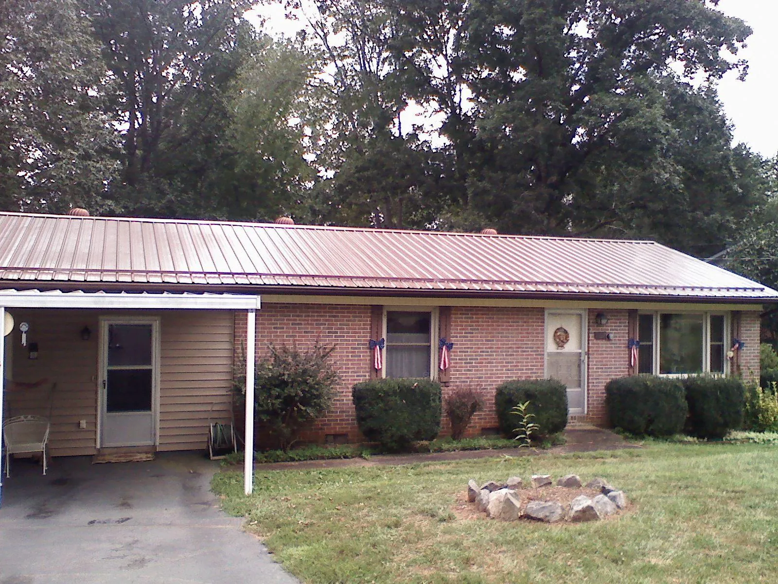 Bronze metal roof and carport on a brick ranch home — Roof Repair work by our crew in Bingham Canyon